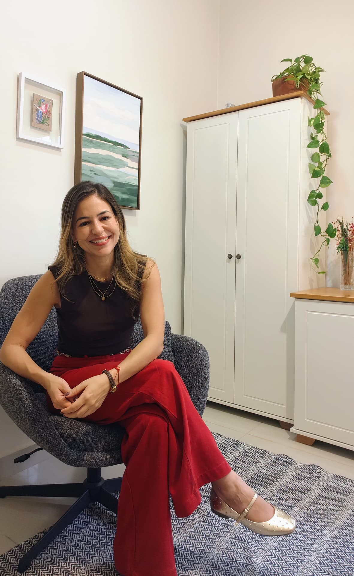 Camila Murad, psicóloga clínica, sentada em sua sala de atendimento
